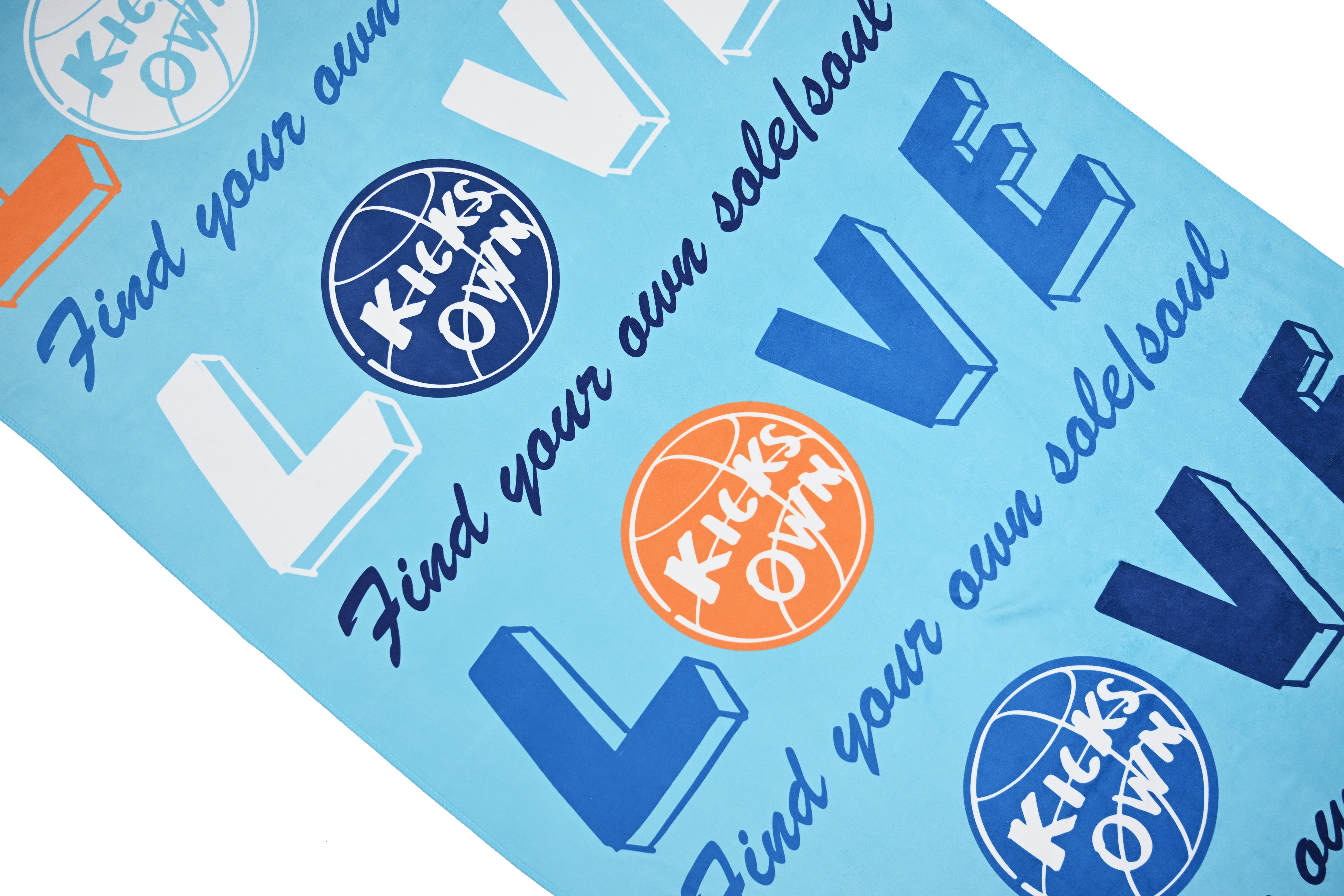 Textile with 'KicksOwn' branding and motivational phrases on a blue background